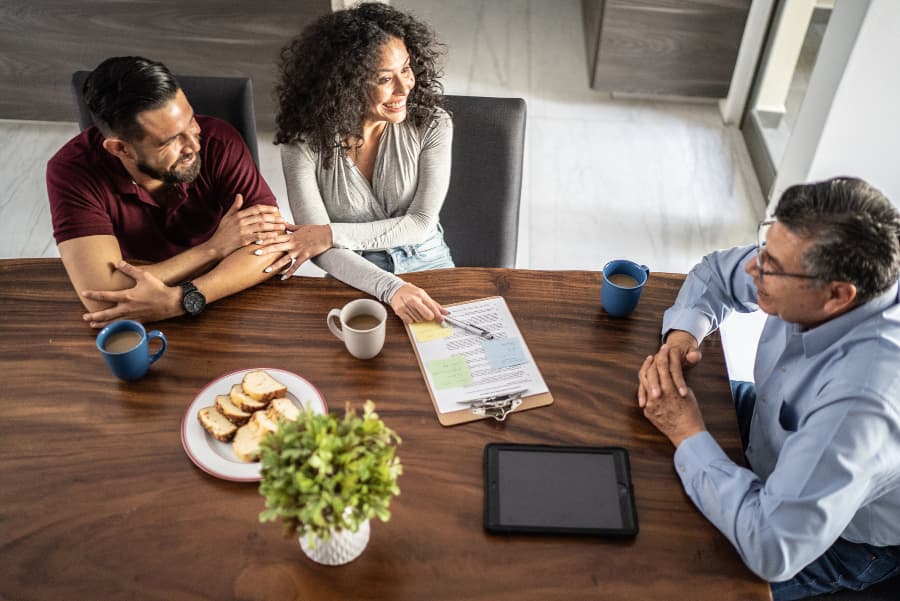 Couple having meeting with real estate broker in dining room of their home