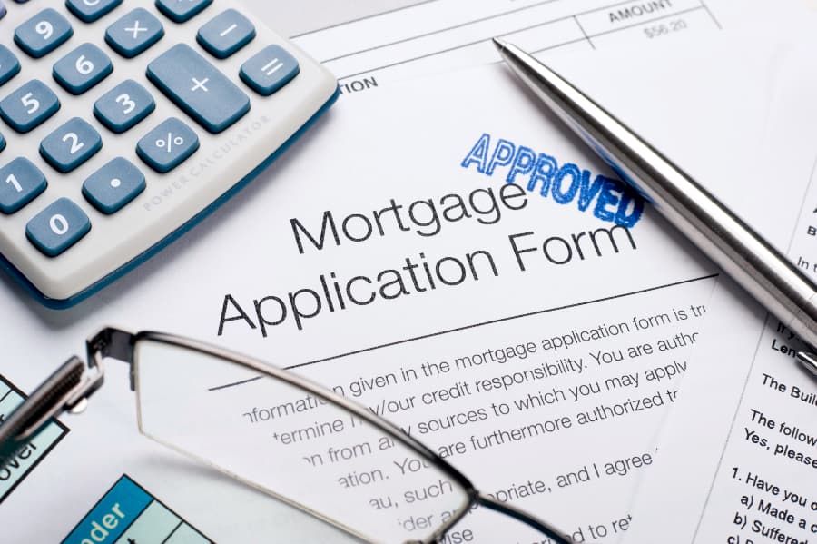 Mortgage application form with calculator and pen