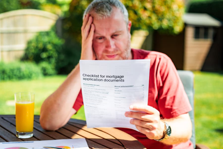 Person reading mortgage application document checklist